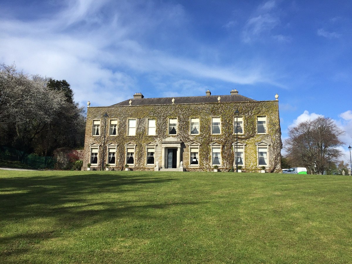 Expert Removals A large mansion in the middle of a grassy field.