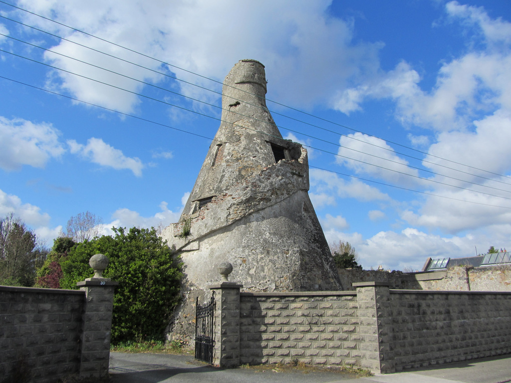 Expert Removals A stone tower in the middle of a street.