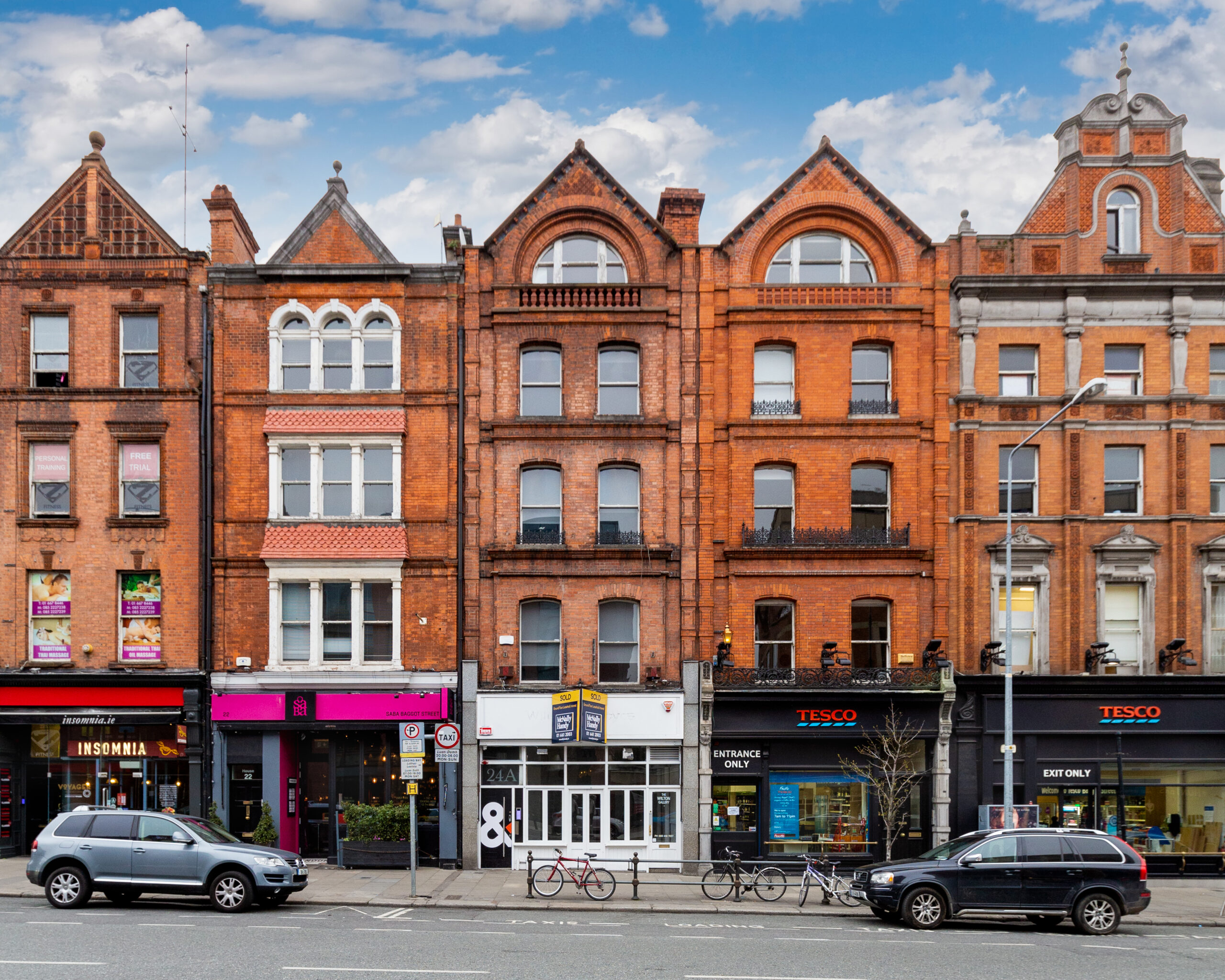 Expert Removals A row of buildings with cars parked in front of them.